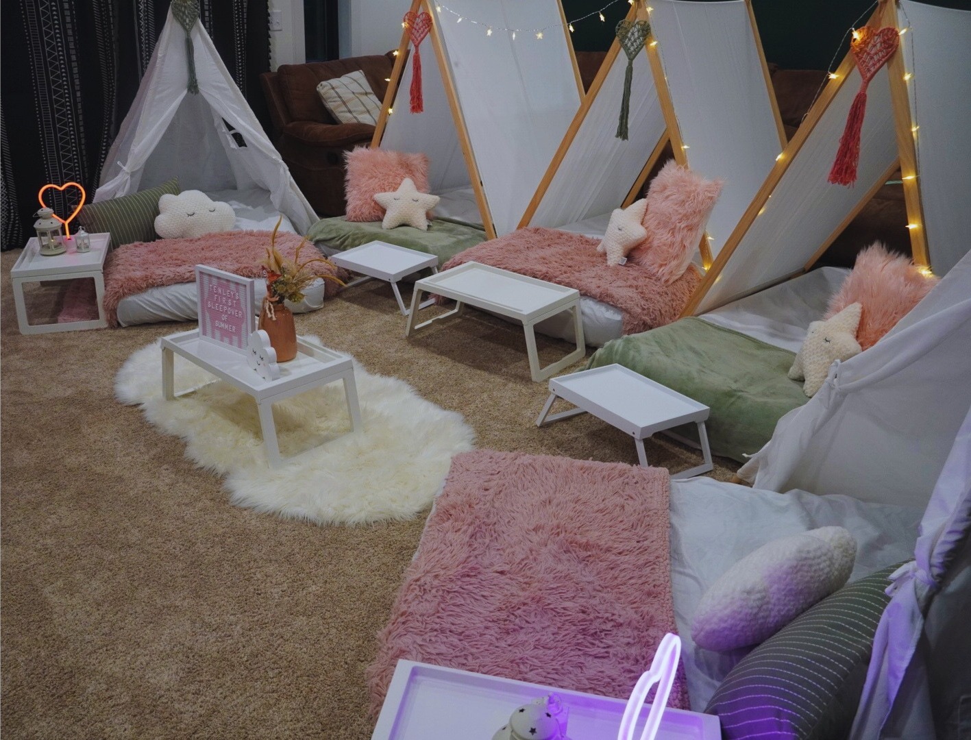 Multiple sleepover tents styled with blush and sage décor