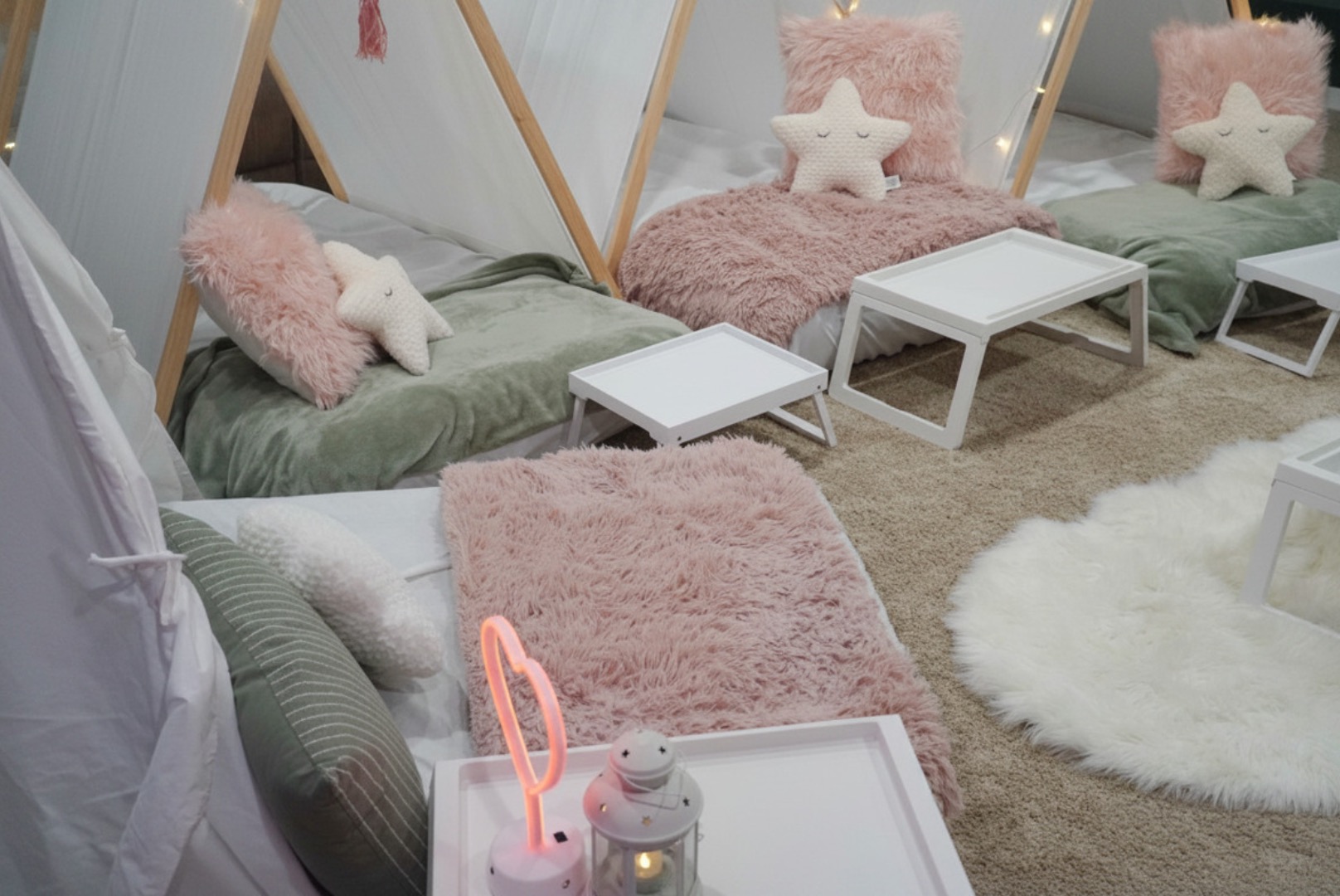 Sleepover tent setup with pink and sage pillows