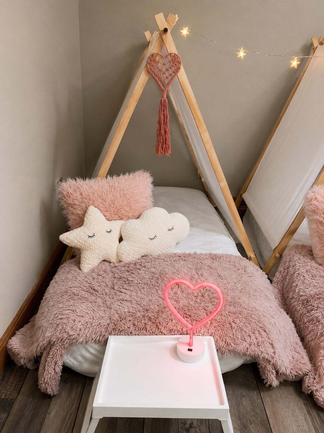 Single pink tent with star and cloud pillows and neon heart lamp